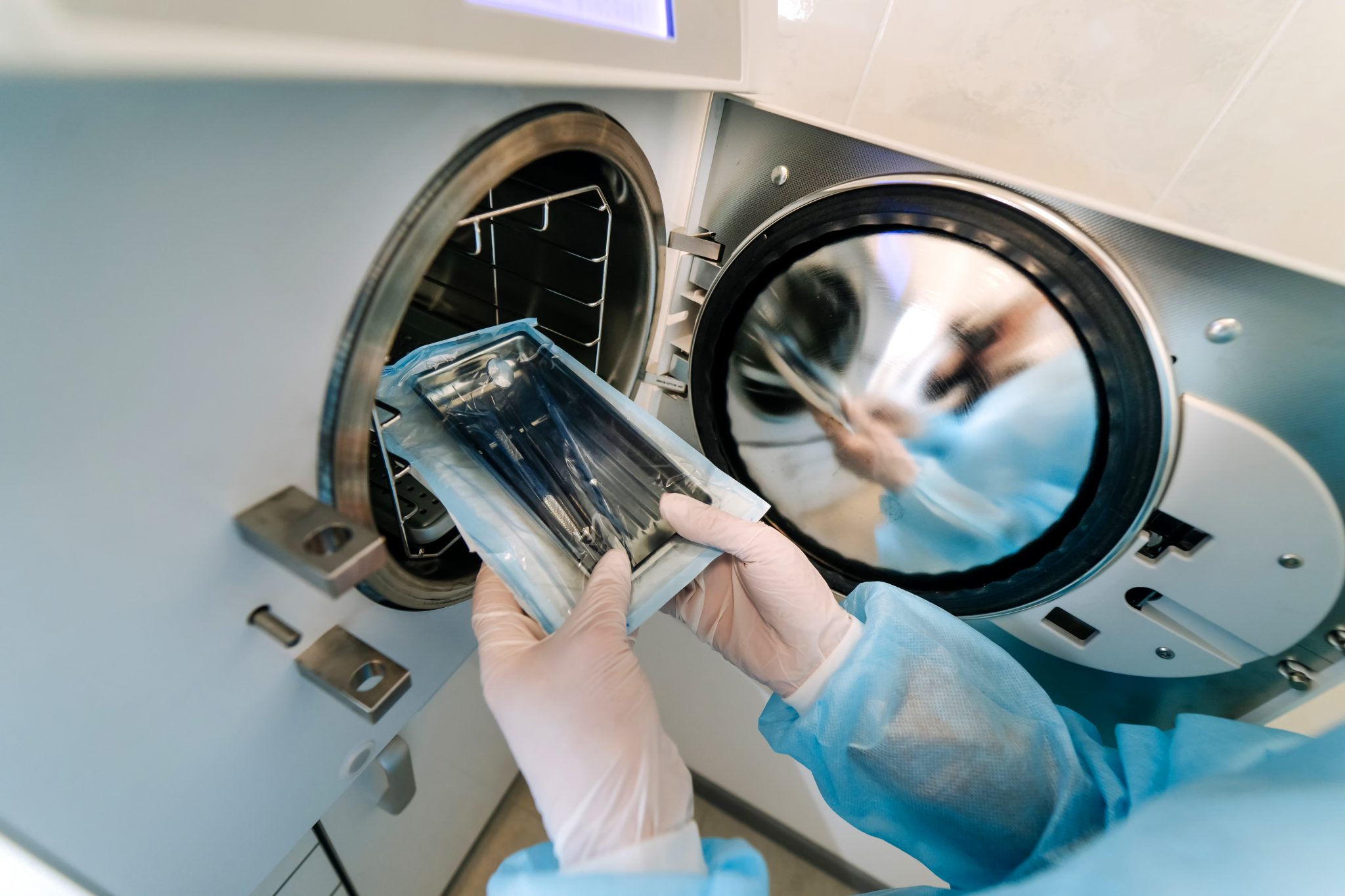 Female nurse doing sterilization of dental medical instruments in